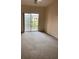 Living room area with carpeted floors and a sliding door to a balcony at 5500 Metrowest Blvd # 304, Orlando, FL 32811