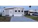 Gray manufactured home with white door and windows, golf cart, and car in driveway at 9000 Us Highway 192 # Lot 316, Clermont, FL 34714