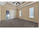 Spacious bedroom features a tray ceiling, neutral walls, carpet, and a sliding glass door at 706 Santee Terre Ln, Winter Garden, FL 34787