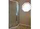 Bathroom shower encased in a clear glass door with silver trim and an octagon-shaped frosted window at 1124 Chateau Cir, Minneola, FL 34715