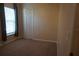 Bedroom featuring neutral carpet, window with curtain, and white bi-fold closet doors at 1124 Chateau Cir, Minneola, FL 34715