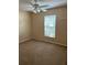 Bedroom showcasing neutral carpet and walls, ceiling fan, and window with blinds at 1124 Chateau Cir, Minneola, FL 34715