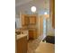 Functional kitchen featuring light wood cabinets, neutral countertops and floors, and modern lighting fixtures at 1124 Chateau Cir, Minneola, FL 34715