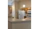Functional kitchen with wooden cabinetry, white appliances, and a convenient breakfast bar at 1124 Chateau Cir, Minneola, FL 34715