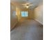 Open living room with neutral carpeting, natural light, and ceiling fan at 1124 Chateau Cir, Minneola, FL 34715