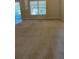 Large living room featuring neutral carpeting and a sliding glass door for natural light at 1124 Chateau Cir, Minneola, FL 34715