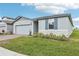 New home exterior featuring a garage, side yard, and brick driveway at 1489 Sea Glass Rd, Haines City, FL 33844