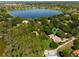 Aerial view showing a house nestled in a tree-lined community near a lake at 1126 Kelso Blvd, Windermere, FL 34786