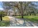 Long driveway leading to a ranch home with mature trees at 1126 Kelso Blvd, Windermere, FL 34786