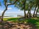 Peaceful lakeside setting with a bench under shade trees at 1126 Kelso Blvd, Windermere, FL 34786