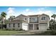 Charming two-story home with a two-car garage, landscaped yard, and a welcoming red front door at 2675 Ginseng Ivy St, Apopka, FL 32703