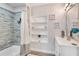 Bathroom featuring a bathtub with decorative gray tile, shelving, and modern vanity at 809 E Ridgewood St, Orlando, FL 32803