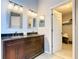 Bathroom featuring a double sink vanity with dark wood cabinets and decorative mirrors at 215 Riggs Cir, Davenport, FL 33897