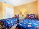 Bright bedroom with twin beds, Super Mario themed bedding, and a shared nightstand at 215 Riggs Cir, Davenport, FL 33897