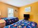 Bedroom with bright yellow walls, a window overlooking the pool, and a television at 215 Riggs Cir, Davenport, FL 33897