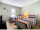 Light and bright bedroom with neutral paint, two beds and a large window at 215 Riggs Cir, Davenport, FL 33897