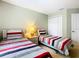 This bedroom features two beds with striped bedding, neutral paint, and closet storage space at 215 Riggs Cir, Davenport, FL 33897