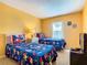 Bedroom with bright yellow walls, a window, and two beds with character print comforters at 215 Riggs Cir, Davenport, FL 33897