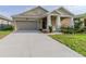 Inviting single-story home featuring a two-car garage, covered porch with columns, and a well-kept front lawn at 5315 Amersham Ln, St Cloud, FL 34771