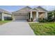 Inviting single-story home featuring a two-car garage, covered porch with columns, and a well-kept front lawn at 5315 Amersham Ln, St Cloud, FL 34771