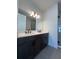 Double vanity bathroom with dark cabinets and a large mirror at 2018 Packing District Way, Orlando, FL 32804