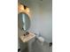 Modern bathroom with round mirror, pedestal sink, and gray tile floor at 2018 Packing District Way, Orlando, FL 32804