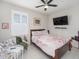 Cozy bedroom featuring tile floors, a ceiling fan, and a flat-screen TV for relaxation at 745 Asturias Rd, Davenport, FL 33837
