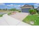 Paver driveway leading to a two-car garage, complemented by tidy landscaping and lush green grass at 745 Asturias Rd, Davenport, FL 33837