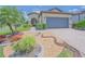 Landscaped front yard featuring decorative rocks, brick edging, and lush plants leading up to a two-car garage at 745 Asturias Rd, Davenport, FL 33837