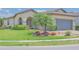 Charming home featuring lush landscaping, a well-manicured lawn, and a beautiful palm tree at 745 Asturias Rd, Davenport, FL 33837