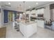 Open-concept kitchen featuring granite countertops, white cabinetry, and a large center island with bar stools at 745 Asturias Rd, Davenport, FL 33837
