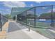 Community tennis court and shaded rest area, secured by a tall metal fence at 745 Asturias Rd, Davenport, FL 33837