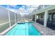 Inviting pool and spa with clear blue water, sheltered by a screened enclosure and paver stone deck at 8834 Cabot Cliffs Dr, Davenport, FL 33896