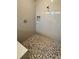 Walk-in shower with neutral tone tile and pebble floor at 4922 Shady Pines Dr, Saint Cloud, FL 34772