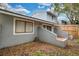 An exterior view of a gray home featuring a small backyard, brick paved patio, and window at 716 Saint Matthew Cir, Altamonte Springs, FL 32714