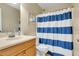 Bathroom features a shower-tub combination with a blue and white striped shower curtain at 716 Saint Matthew Cir, Altamonte Springs, FL 32714