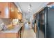 Galley kitchen with wood cabinets, stainless steel sink, and modern appliances at 716 Saint Matthew Cir, Altamonte Springs, FL 32714