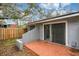 View of the brick paved back patio and sliding glass doors leading to a gray residential home with a fenced-in backyard at 716 Saint Matthew Cir, Altamonte Springs, FL 32714