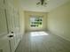Bright bedroom with light tile flooring, ceiling fan, and a large window offering views of the outdoors at 5156 City St # 118, Orlando, FL 32839