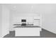 Modern kitchen featuring an island, gray countertops, stainless steel microwave, and white cabinets at 8620 Caribbean Pine Way, Lakeland, FL 33809