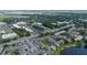 Aerial view showcases a condo community, nearby shops and parking, set against a backdrop of a tranquil lake at 158 Maitland Ave, Altamonte Springs, FL 32701
