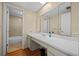 Bathroom featuring a long white vanity, mirror, and entry to the tiled bathtub with shower at 158 Maitland Ave, Altamonte Springs, FL 32701