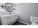 Stylish bathroom featuring a modern vanity with a round mirror, unique lighting, and a toilet at 158 Maitland Ave, Altamonte Springs, FL 32701