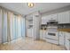 Bright kitchen with white cabinets and appliances, featuring a laundry area and access to outdoor space at 158 Maitland Ave, Altamonte Springs, FL 32701