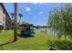 Scenic lakeside view with lush green lawn, storage for canoes, and mature trees offering shade and beauty at 158 Maitland Ave, Altamonte Springs, FL 32701