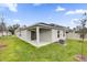 The backyard with covered patio and a well-maintained lawn at 8377 Wilder Pines Ave, Lakeland, FL 33809
