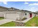 Charming one-story home with a two-car garage, a red door, and a well-maintained front yard at 8377 Wilder Pines Ave, Lakeland, FL 33809