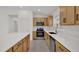 Well lit kitchen with stainless steel appliances, white countertops, and wood-grain cabinets at 8377 Wilder Pines Ave, Lakeland, FL 33809