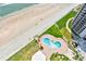 An aerial view of a condo community's beachside pool and manicured grounds on a sunny day at 2545 S Atlantic Ave # 2107-2108, Daytona Beach Shores, FL 32118