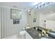 Elegant bathroom features a black granite countertop, designer fixtures, and unique striped wallpaper at 2545 S Atlantic Ave # 2107-2108, Daytona Beach Shores, FL 32118